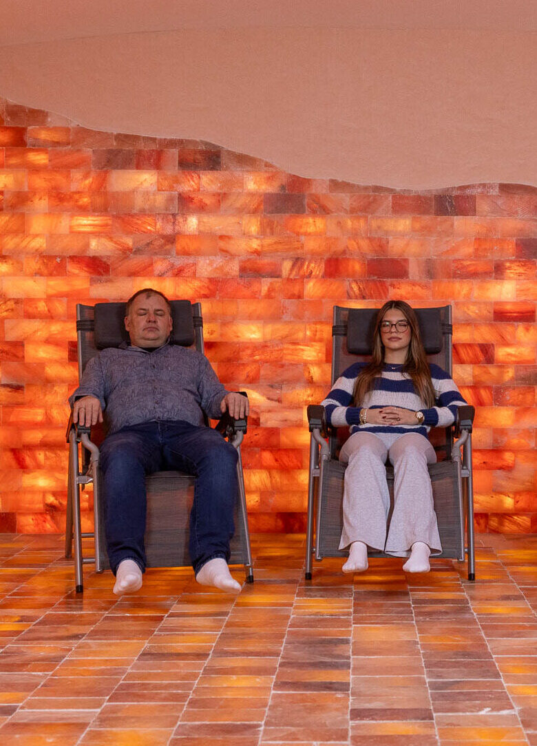 Ein Mann und eine junge Frau liegen jeweils auf einer Liege in der Natursalzoase